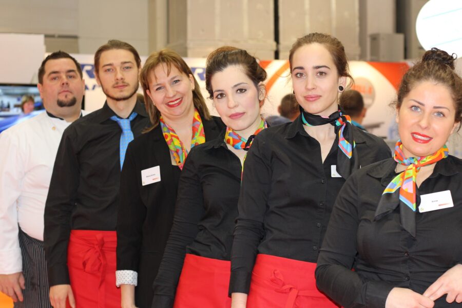 Messeteam in einheitlicher Kleidung am Stand