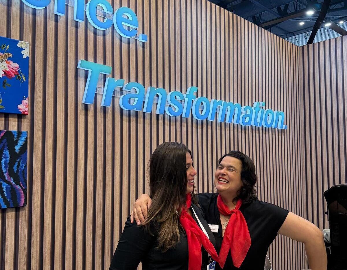 Team am Messestand vor einer Holzwand